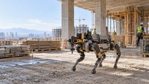 Construction robot operating with a powered tool on a real jobsite